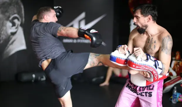 Jason Woodham demonstrating a Muay Thai kick technique with a student