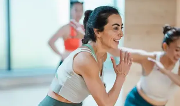 Women warming up during a BODYCOMBAT class at GymNation, preparing for a high-intensity cardio session.